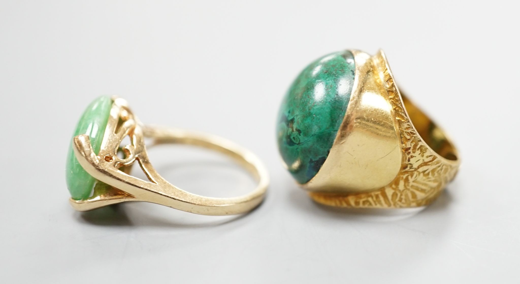 A modern 14k yellow metal and cabochon malachite set dress ring, size F and a similar cabochon jade set ring, size K, gross weight 16.8 grams.